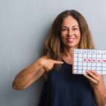 Woman holding a calendar of the menstrual cycle