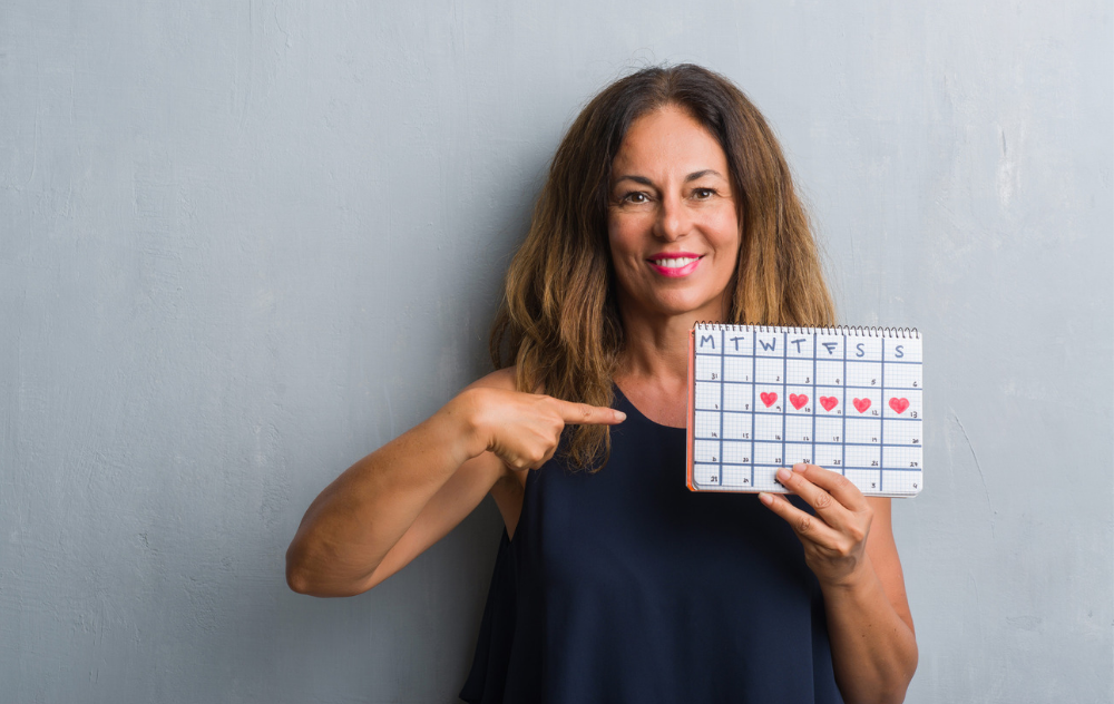 Woman holding a calendar of the menstrual cycle