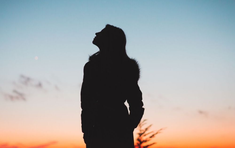 silhouette of a woman staring at the sky