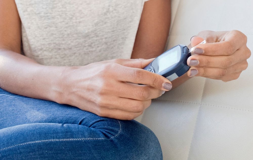 woman measuring her blood sugar levels during her period