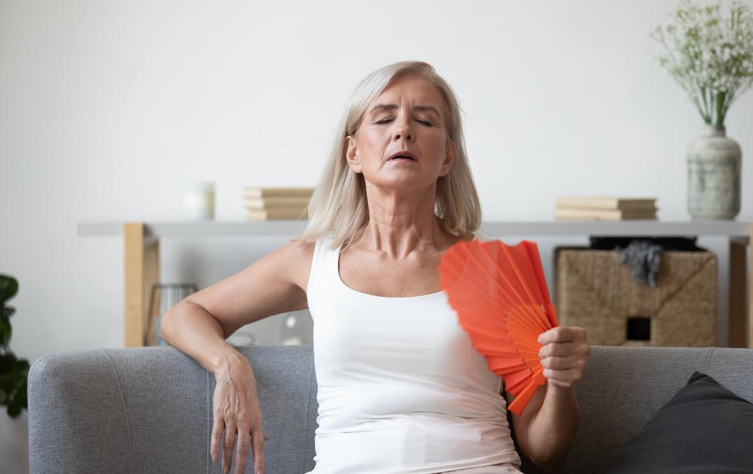 Complications Of High Estrogen Levels 3 A woman fanning herself while having hot flashes.