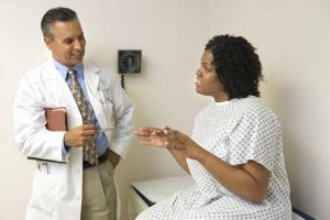 Block woman talking to doctor about fibroids