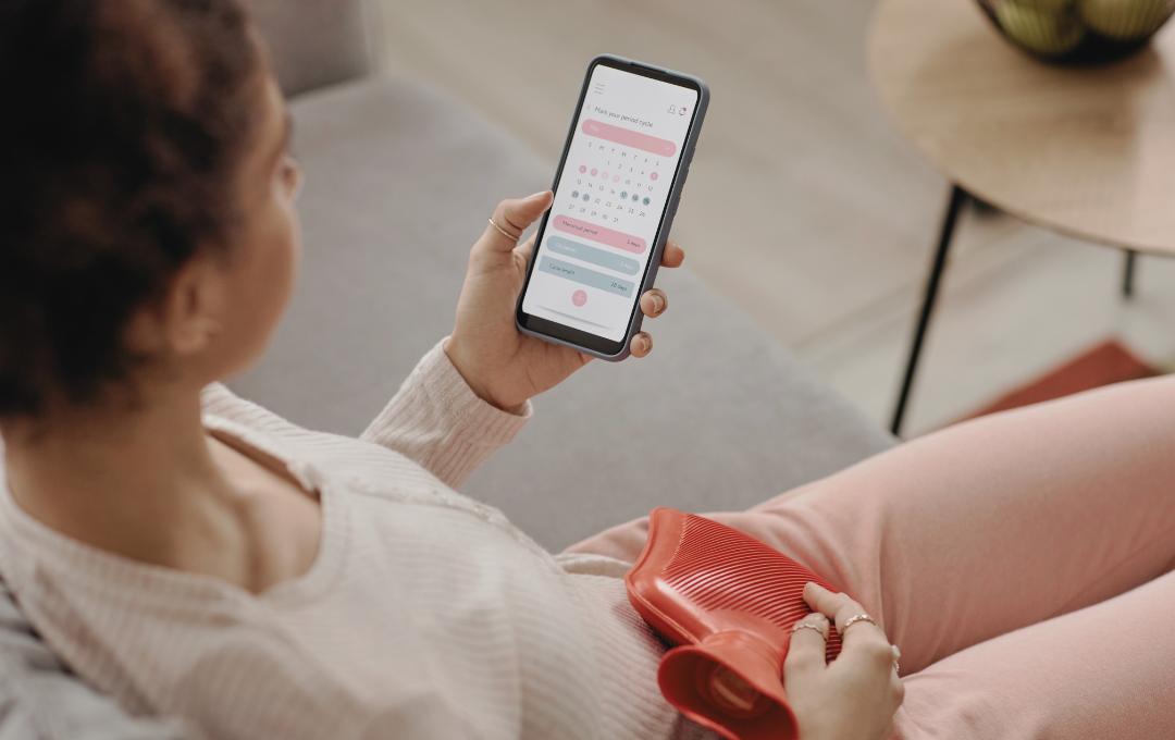 Why Do Fibroids Cause Heavy Bleeding And Clots During A Period? 4 A woman looking at the calendar on her phone counting the extended days of her menstrual cycle and bleeding.