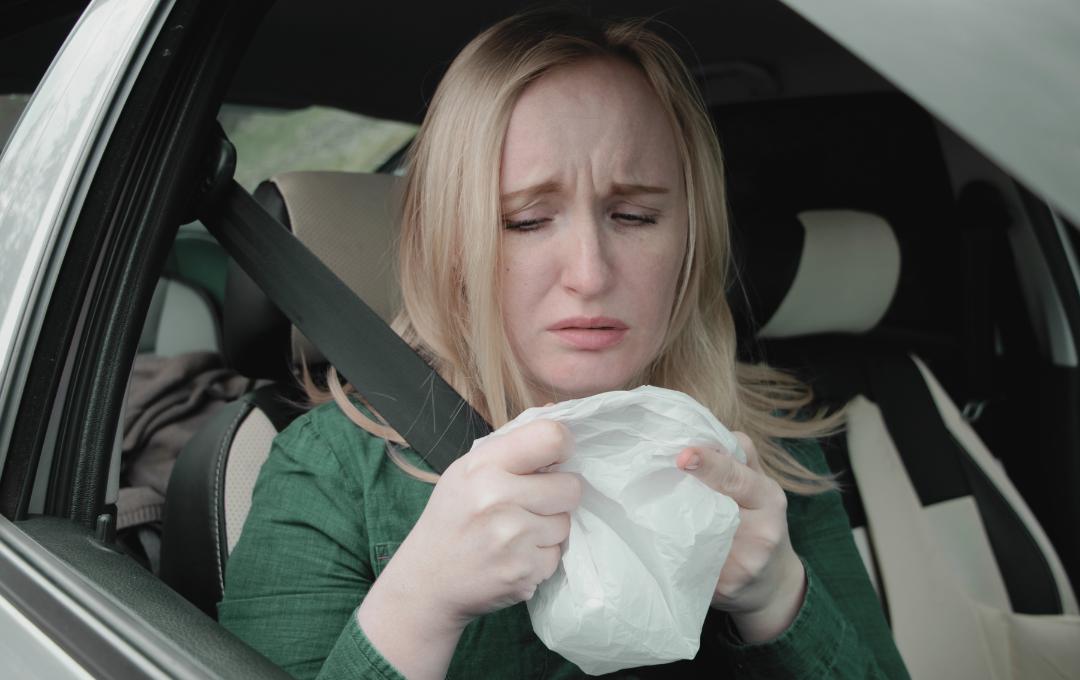 Can Fibroids Cause Nausea And Dizziness? 2 Woman feeling nauseous and holding a vomiting bag.