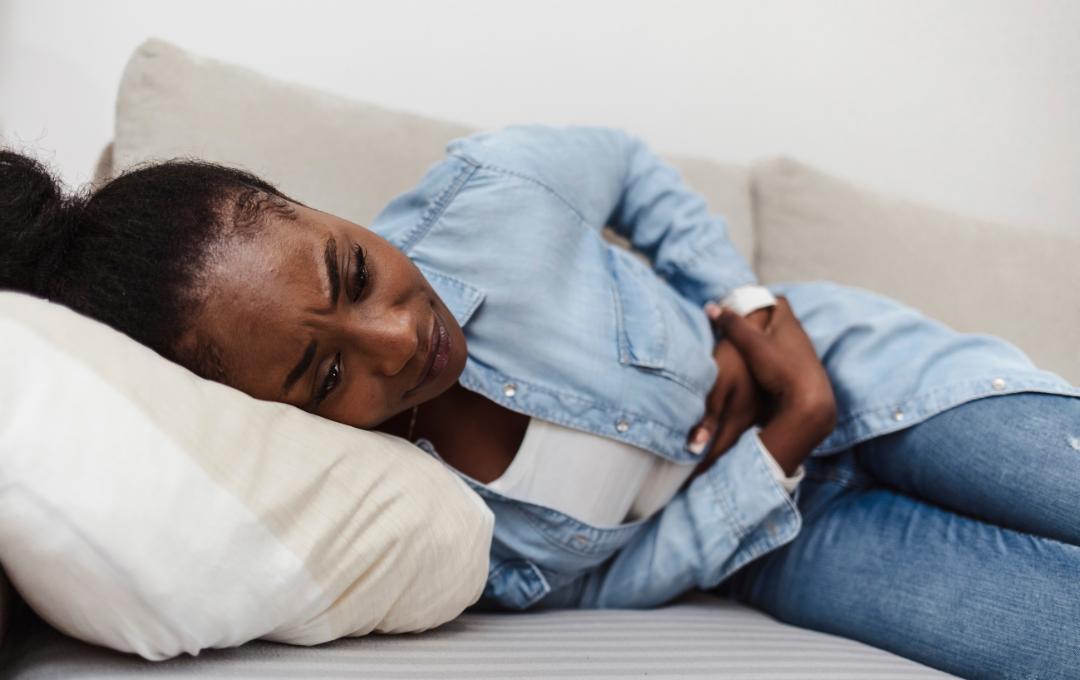 Why Does My Stomach Hurt After Sex? 2 Woman holding her stomach due to stomach pain.