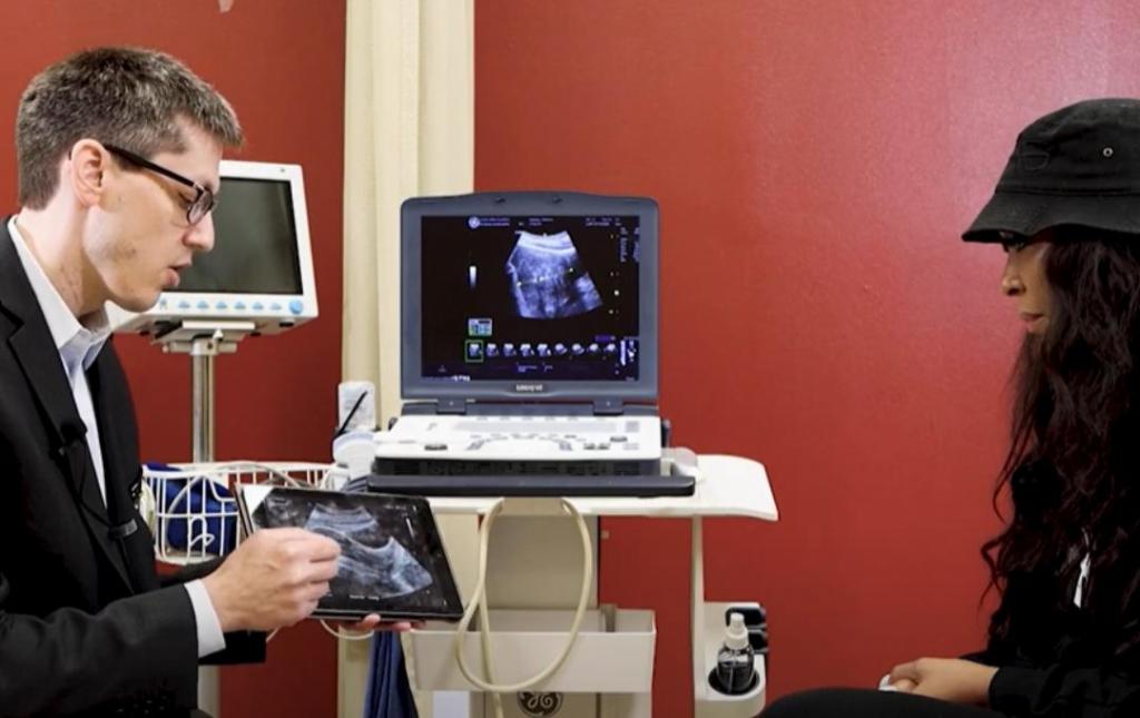 White explaining UFE to patient