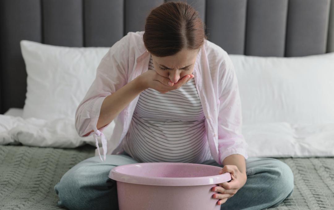 Can Fibroids Cause Nausea And Dizziness? 3 A pregnant woman feeling nauseous and throwing up in a bowl.
