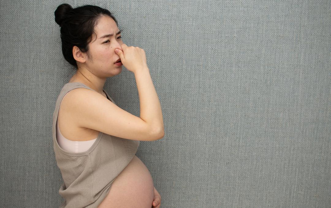 What Does Brown Vaginal Discharge Mean? 3 A pregnant woman holding her nose to block the smell from brown discharge.